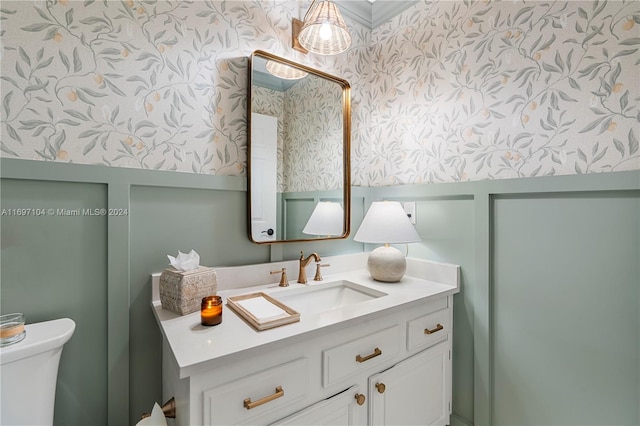 bathroom with vanity, toilet, and crown molding