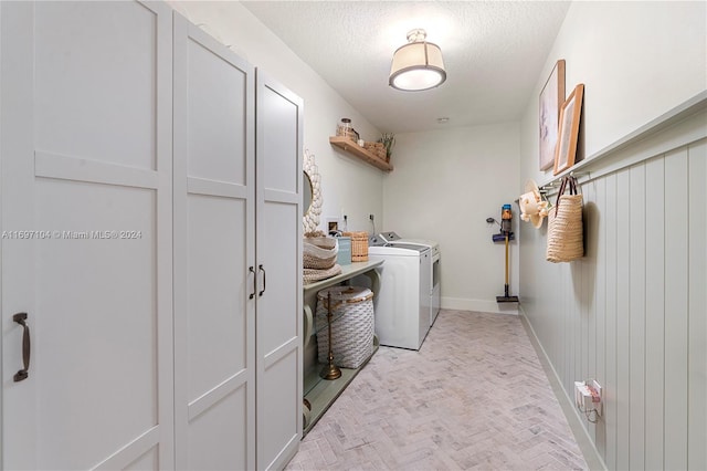 laundry room featuring washing machine and dryer and a textured ceiling