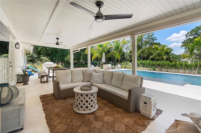 view of patio featuring ceiling fan and an outdoor living space with a fire pit