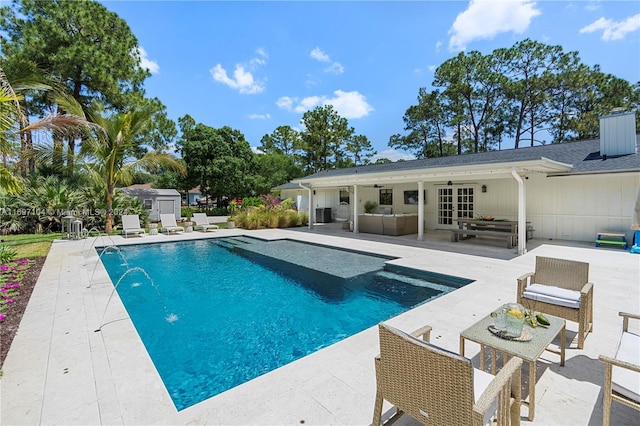 view of swimming pool with ceiling fan, french doors, an outdoor living space, pool water feature, and a patio area