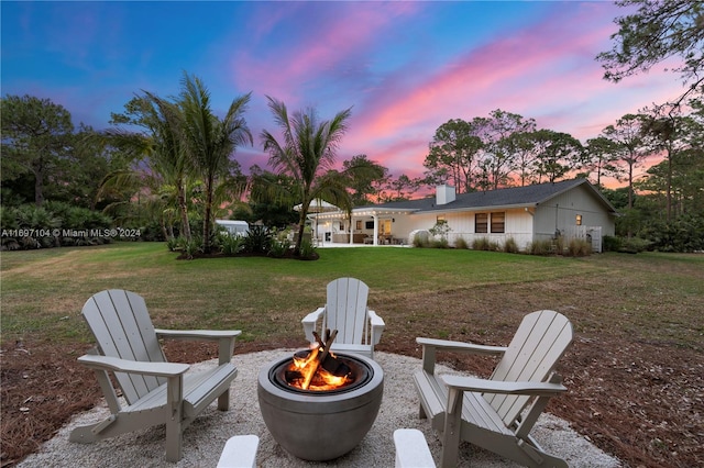 yard at dusk featuring a fire pit