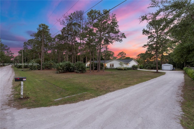 view of front of property with a lawn, a garage, and an outbuilding