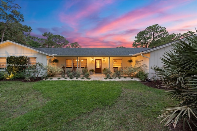 back house at dusk with a lawn