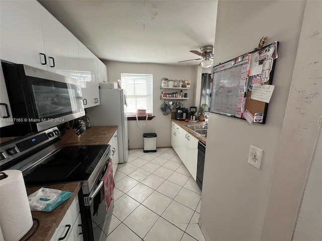 kitchen featuring ceiling fan, white cabinetry, sink, light tile patterned flooring, and appliances with stainless steel finishes