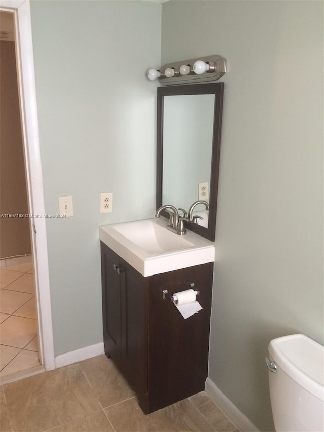 bathroom featuring tile patterned flooring, vanity, and toilet