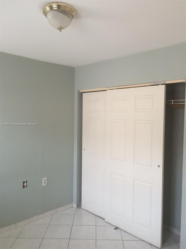 unfurnished bedroom with a closet and light tile patterned flooring