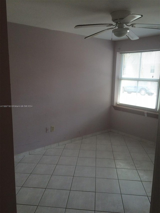 tiled spare room with ceiling fan