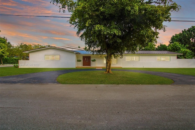 ranch-style home with a yard