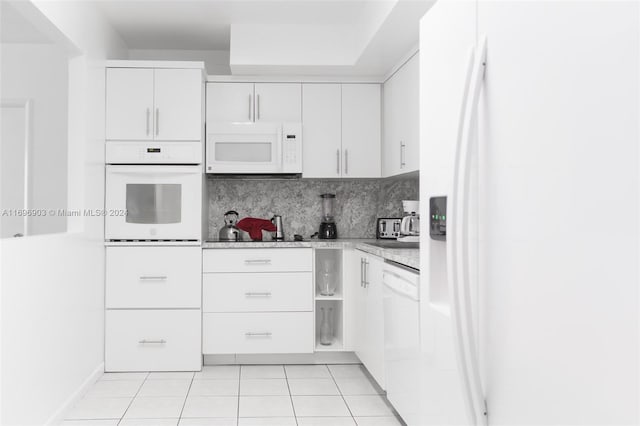 kitchen with white cabinets, decorative backsplash, and white appliances