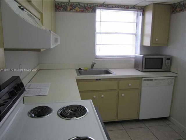 kitchen featuring light tile patterned flooring, white appliances, green cabinetry, and sink