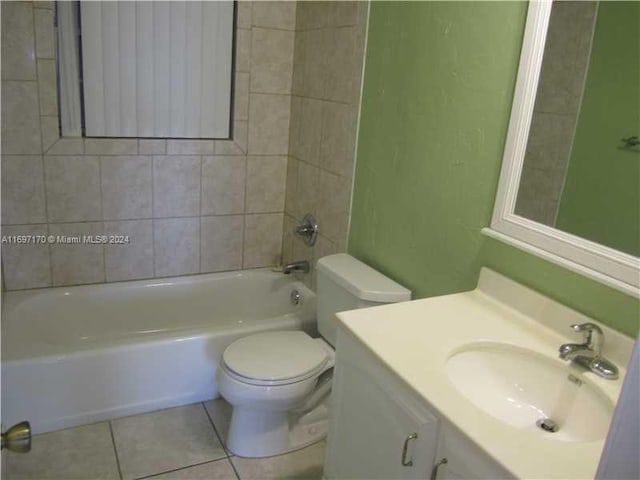 full bathroom with tile patterned floors, vanity, tiled shower / bath, and toilet