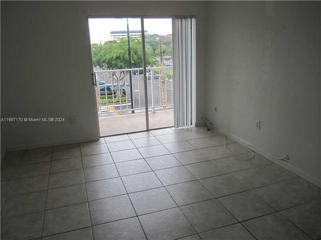 unfurnished room featuring tile patterned flooring and plenty of natural light