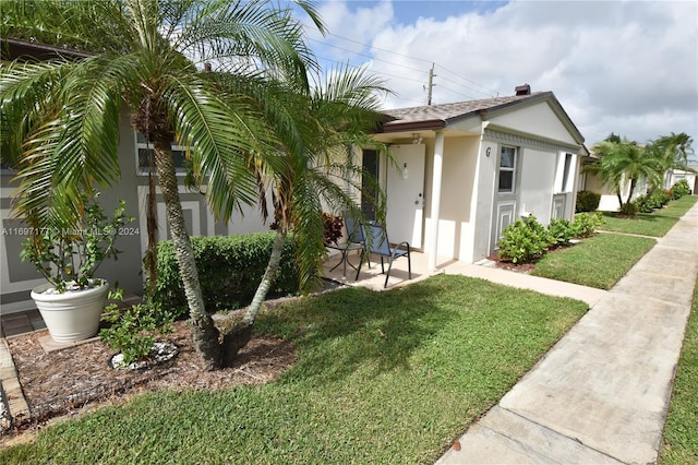 view of front of property featuring a front yard and a patio area