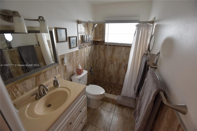 bathroom with a shower with shower curtain, vanity, toilet, and tile walls