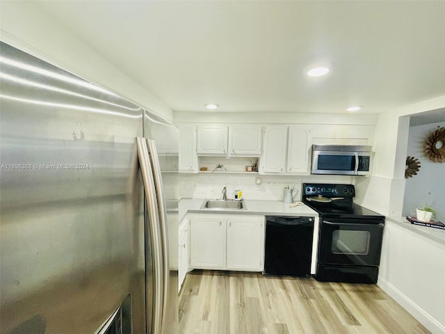 kitchen with white cabinetry, sink, tasteful backsplash, light hardwood / wood-style flooring, and black appliances