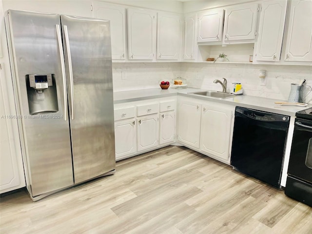 kitchen with sink, tasteful backsplash, light hardwood / wood-style flooring, white cabinets, and black appliances