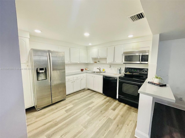 kitchen with black appliances, sink, tasteful backsplash, light hardwood / wood-style floors, and white cabinetry