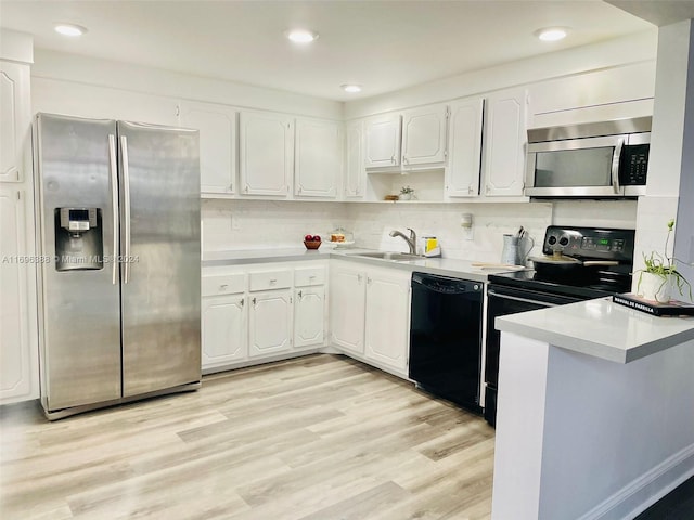 kitchen featuring white cabinets, black appliances, and light wood-type flooring