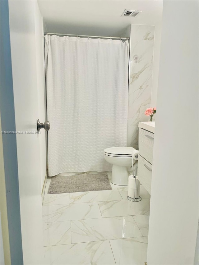 bathroom with a shower with curtain, vanity, and toilet