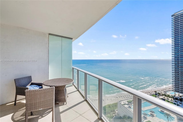 balcony with a water view and a beach view