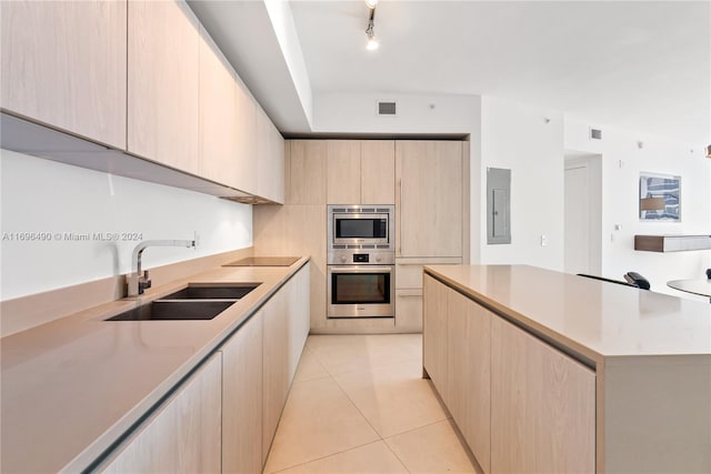 kitchen with sink, stainless steel double oven, electric panel, light brown cabinetry, and light tile patterned floors