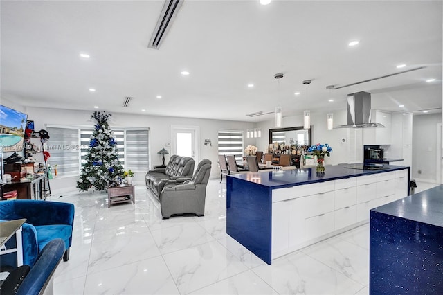 kitchen with black electric stovetop, extractor fan, hanging light fixtures, and white cabinets