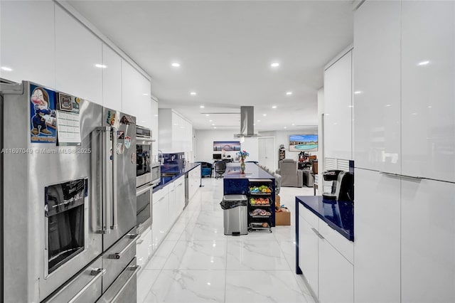 kitchen featuring white cabinetry, appliances with stainless steel finishes, and island range hood