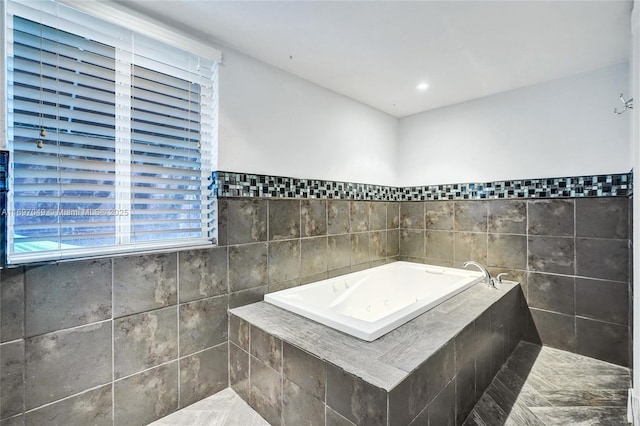 bathroom featuring tile walls and tiled tub