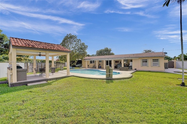 back of house featuring a fenced in pool, a patio, a yard, and ceiling fan