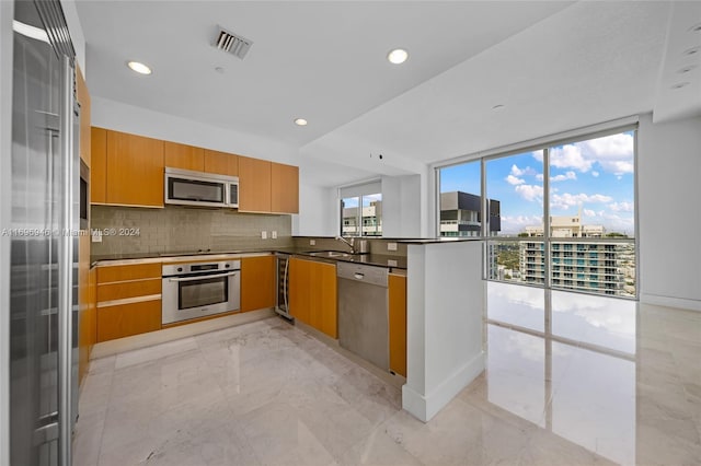 kitchen featuring backsplash, kitchen peninsula, stainless steel appliances, and wine cooler