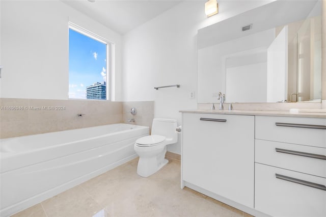 bathroom featuring tile patterned floors, vanity, a bathtub, and toilet