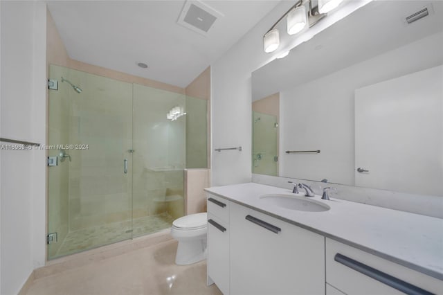 bathroom with vanity, toilet, and a shower with door