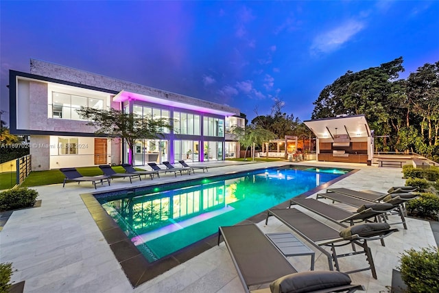 pool at dusk featuring a patio area