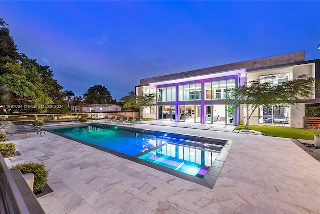 pool at dusk with a patio area