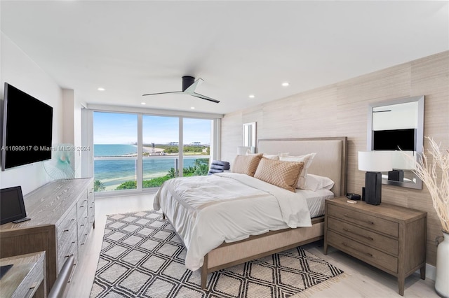 bedroom with a water view, ceiling fan, and light hardwood / wood-style floors