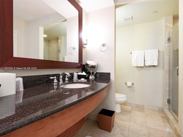 bathroom with toilet, sink, a shower with shower door, and tile patterned flooring