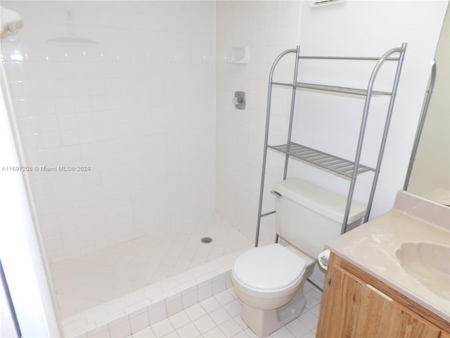 bathroom featuring tiled shower, tile patterned flooring, vanity, and toilet