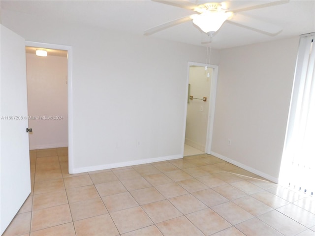 tiled spare room with ceiling fan