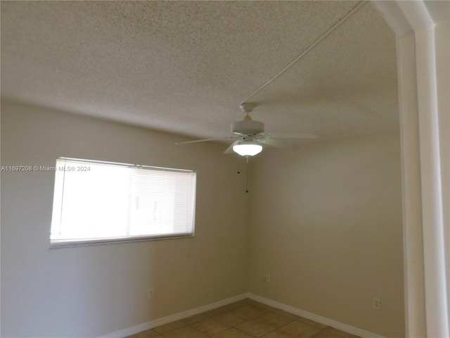 unfurnished room with tile patterned flooring, ceiling fan, and a textured ceiling