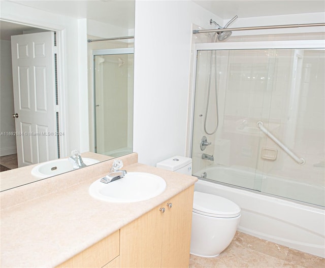 full bathroom with vanity, toilet, and enclosed tub / shower combo