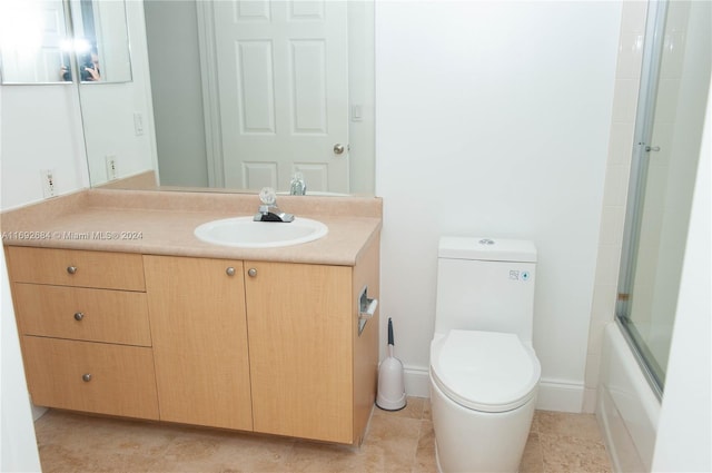 full bathroom with shower / bath combination with glass door, tile patterned floors, vanity, and toilet