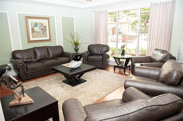 living room featuring a healthy amount of sunlight, light hardwood / wood-style floors, and ornamental molding