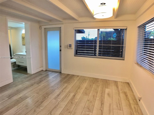 interior space with light hardwood / wood-style floors and beam ceiling