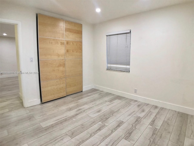 unfurnished bedroom featuring a closet and light hardwood / wood-style floors