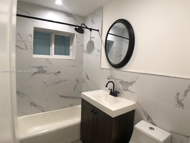 full bathroom featuring vanity, toilet, tile walls, and tiled shower / bath combo