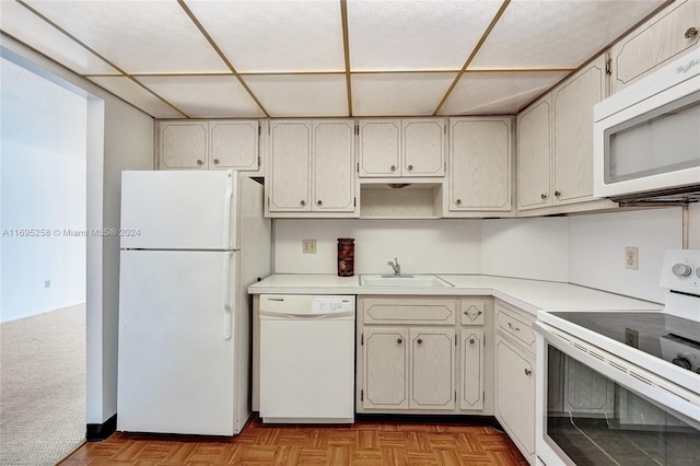 kitchen featuring white appliances, sink, and light parquet flooring