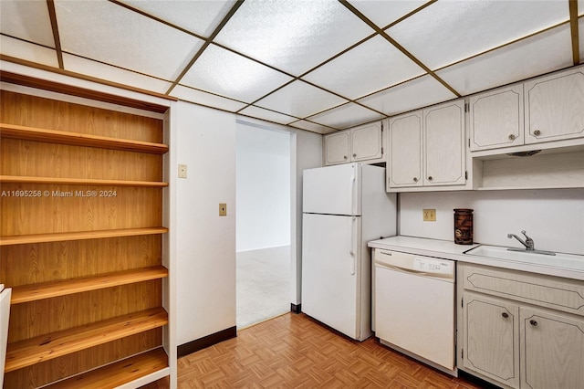 kitchen featuring white appliances, white cabinetry, light parquet floors, and sink