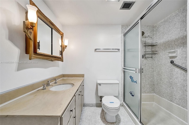 bathroom featuring tile patterned floors, vanity, toilet, and a shower with door