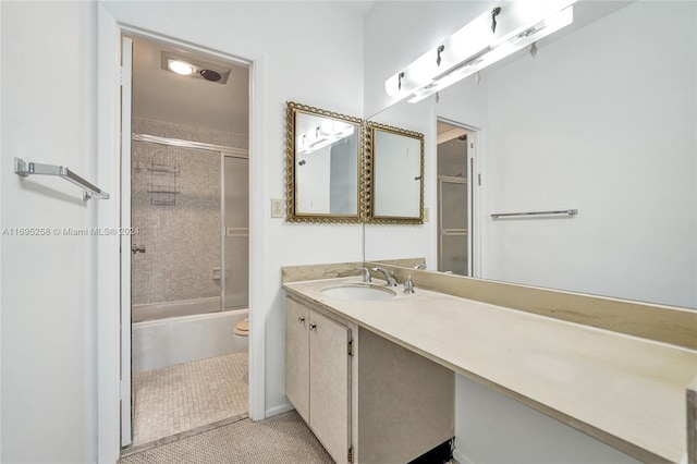 full bathroom featuring tile patterned floors, vanity, toilet, and enclosed tub / shower combo