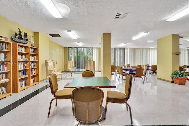 dining space with a textured ceiling and expansive windows